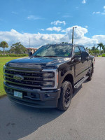 2023 Ford F-350 Super Duty in black, showcasing powerful design and robust features, parked under a blue sky.