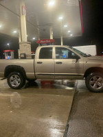 2005 Dodge Ram 1500 SLT parked at a gas station, showcasing its all-wheel drive and plush interior.
