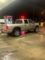 2005 Dodge Ram 1500 SLT parked at a gas station with a shiny exterior under nighttime lights.