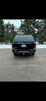 2005 Chevrolet Trailblazer LT rear view, showcasing its black exterior and tow hitch, parked outdoors.