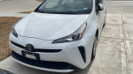 Front view of a 2021 Toyota Prius in white, showcasing its sleek design and modern features.