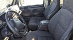 Interior view of a 2002 Jeep Wrangler showcasing its front seats and steering wheel.