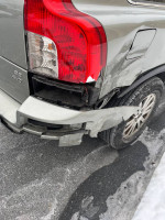 Damaged rear corner of a 2008 Volvo XC90 with scratches and dings