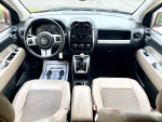 Interior view of a 2014 Jeep Compass Latitude with leather seats and modern dashboard features.