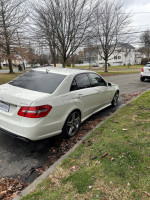 2010 Mercedes-Benz E-Class E550 white sedan parked with clear view of rear and side in a residential area