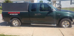 2001 Ford F-150 work truck with a black cargo box and junk removal service advertisement.