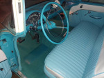 Interior of a 1955 Chevrolet Station Wagon with turquoise upholstery and classic dashboard