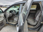 Interior view of a 2011 Chevrolet Traverse with gray seats and dashboard, showing front and back seating areas.