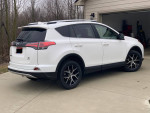 2016 Toyota RAV4 SE AWD in Super White with black and saddle interior, parked in a driveway.