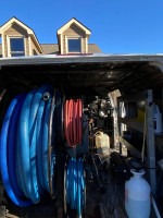 Interior view of a 2004 Ford E-250 carpet cleaning van showing hoses and equipment for cleaning services.