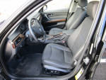 Interior view of a 2011 BMW 328i XDrive with black leather seats and wood accents.