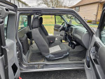 Interior view of a 2010 Ford Ranger XLT showing front and rear seats in army green color.