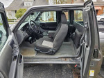 Interior view of a 2010 Ford Ranger XLT with gray seats and open driver's side door.