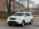 2014 Honda Pilot EX-L parked on street, showcasing clean design and alloy wheels.