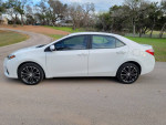 2016 Toyota Corolla S FWD parked on a scenic road, showcasing its sleek design and sporty wheels.