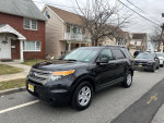 2014 Ford Explorer XLT in black parked on the street, showcasing its sleek design and new tires.