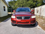Front view of a 2005 Volkswagen Touareg V6 SUV in red with low mileage and clean title.