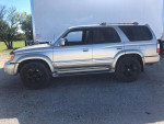 2002 Toyota 4Runner SUV in silver with black wheels parked outdoors, showcasing good condition and low mileage