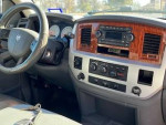 Interior view of a 2006 Dodge Ram 2500 with wooden accents and modern sound system.