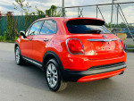 2016 FIAT 500X Easy Edition in orange, parked on the street, showcasing its clean design and alloy wheels.
