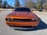 Front view of a bright orange 2011 Dodge Challenger, customized, with low mileage and clean title.