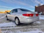 2005 Honda Accord LX Sedan in silver parked in a snowy area, showcasing its sleek design and clean exterior.