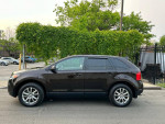 Side view of a 2013 Ford Edge SEL FWD in black with alloy wheels parked outdoors.