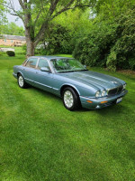 2003 Jaguar XJ8 in Zircon Blue, low mileage, parked on grass with a clean exterior and luxurious interior.