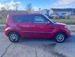 Side view of a 2013 Kia Soul in red color, showcasing alloy wheels and clean condition.