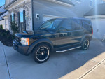 2006 Land Rover LR3 in black with beige interior, parked in driveway, displaying low mileage of 104,000.