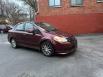 2008 Suzuki SX4 sedan parked on a street, showcasing its reliability and gas efficiency.