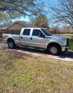 2016 Ford F250 Super Duty crew cab pickup truck in excellent condition, parked on the road under trees.