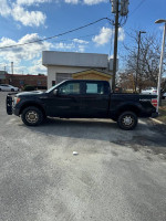 2010 Ford F-150 Supercrew V8 truck parked outside, showcasing its four-wheel drive and exterior