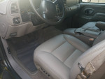 Interior view of a 1999 Chevrolet Suburban with leather seats and modern dashboard features.