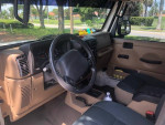 Interior view of a 2002 Jeep Wrangler Sahara with lifted seats and stylish dashboard features.