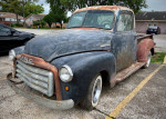 1950 GMC 100 Half Ton Step Side truck in need of restoration, parked on a street.