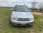 2008 Kia Sedona van with 92,000 miles parked on grass, spacious family vehicle with cold A/C and new tires.
