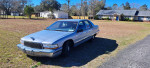1995 Buick Roadmaster parked in front of a house, showcasing its classic design and good condition.
