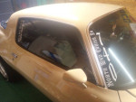 Close-up of a 1980 Chevrolet Camaro showcasing its body and interior details in a garage.