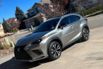 2018 Lexus NX 300 F Sport in silver parked in a residential area with blue sky