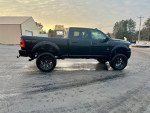 2021 Ram 2500 Crew Cab Black Widow truck with a 6-inch lift and 37.5-inch tires parked on a snowy road