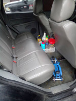 Interior view of a 2006 Jeep Cherokee Laredo with clean gray leather seats and maintenance items.