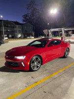 2018 Chevrolet Camaro 1LT Coupe in red color parked at night, showcasing sleek design and modern features.