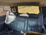 Interior of a 2005 Chevrolet Suburban showing clean leather back seats with seatbelts.