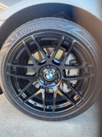 Close-up of a black alloy wheel on a 2013 BMW 5 Series showcasing its clean design and tire tread.