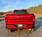 Rear view of a 2020 GMC Denali HD truck in Red Quartz Tintcoat, showcasing its immaculate condition and luxurious design.