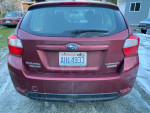 Rear view of a 2012 Subaru Impreza hatchback, slightly dusty with a Washington license plate.