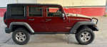 2010 Jeep Wrangler Unlimited Rubicon in red, showcasing off-road capability and modern features.
