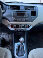 Interior view of a 2013 Kia Rio showing dashboard, controls, and automatic transmission gear shift.