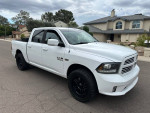 2013 Ram 1500 Sport Crew Cab in white, showcasing its sleek design and off-road tires on a residential street.